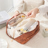 A brown floral makeup tote bag is open, showing various cosmetic products and a gold brush.