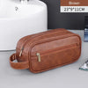 A brown leather travel cosmetic bag with a zipper and strap is shown next to a white sink.