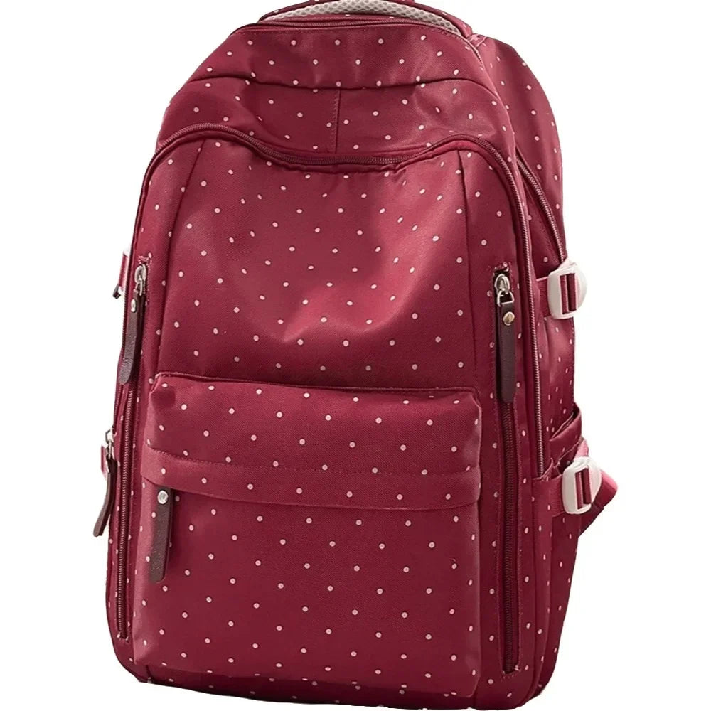 A maroon corduroy backpack with a white polka dot pattern and brown accents.