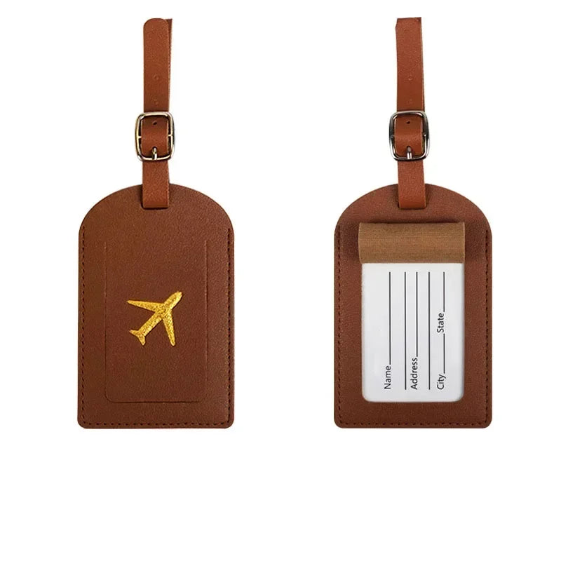 Two brown PU leather luggage tags with metal loops for travel and identification.