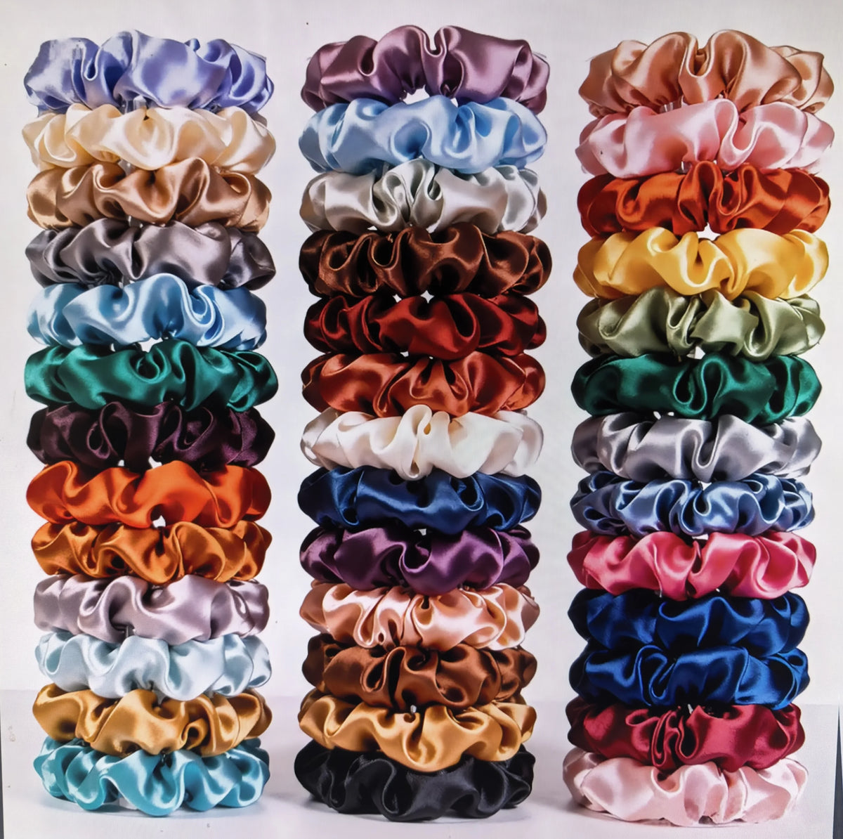 A display of 19 thin scrunchies hair ties in various shades of purple, pink, green, and brown.