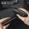A hand holds a slim black leather card holder with a geometric design against a dark background.