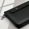 A black multi-card men's commuter wallet with a zippered closure is shown on a white surface.