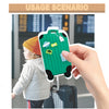A hand holds a green luggage tag with various tags attached, next to a child and a blue suitcase.