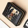 A black PU leather double-zip clutch wallet featuring a gold cartoon print and gold stitching.