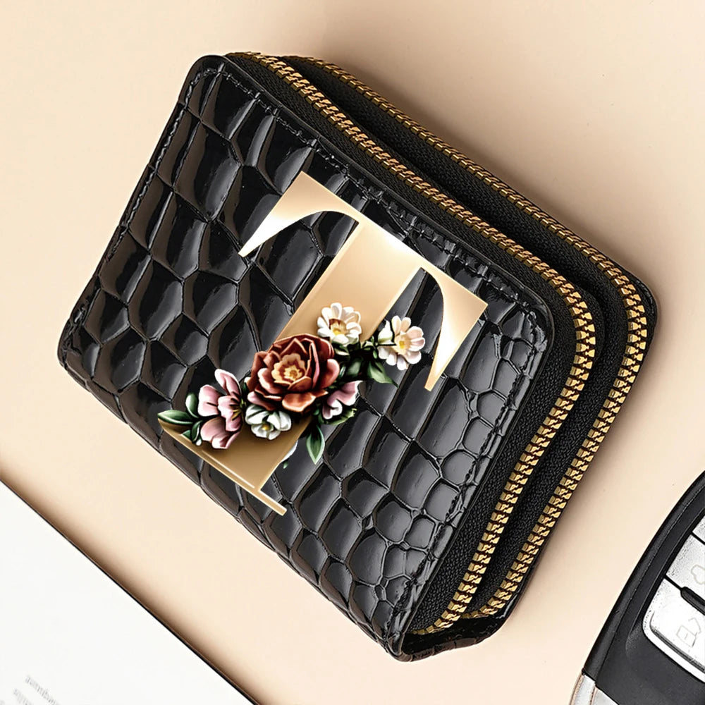 A black PU leather double-zip clutch wallet featuring a gold cartoon print and gold stitching.