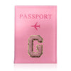 A pink leather passport holder with gold embossed letter G and a small airplane symbol.