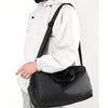 A person wearing a white hoodie is carrying a black multifunctional dry/wet separation travel backpack.