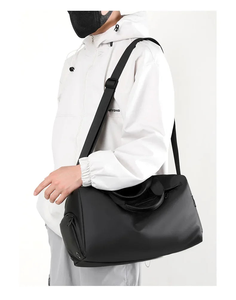 A person wearing a white hoodie is carrying a black multifunctional dry/wet separation travel backpack.