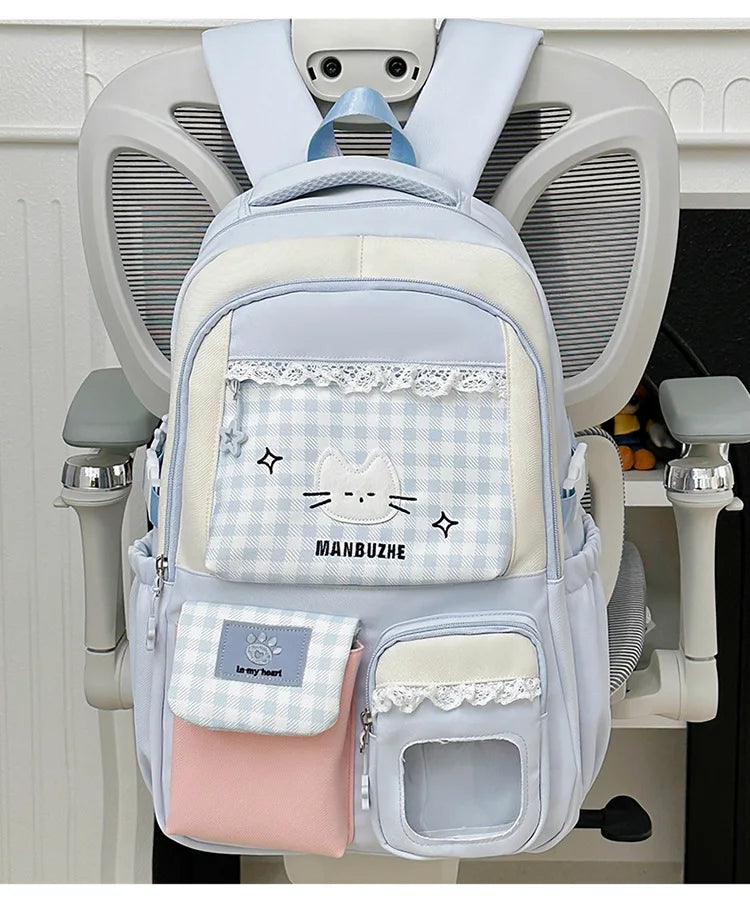 A light blue and pink Oxford backpack featuring a cat design and a laptop compartment.