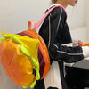 A person is holding a colorful novelty backpack shaped like a cheeseburger.