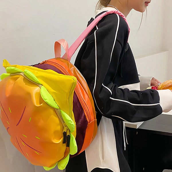 A person is holding a colorful novelty backpack shaped like a cheeseburger.