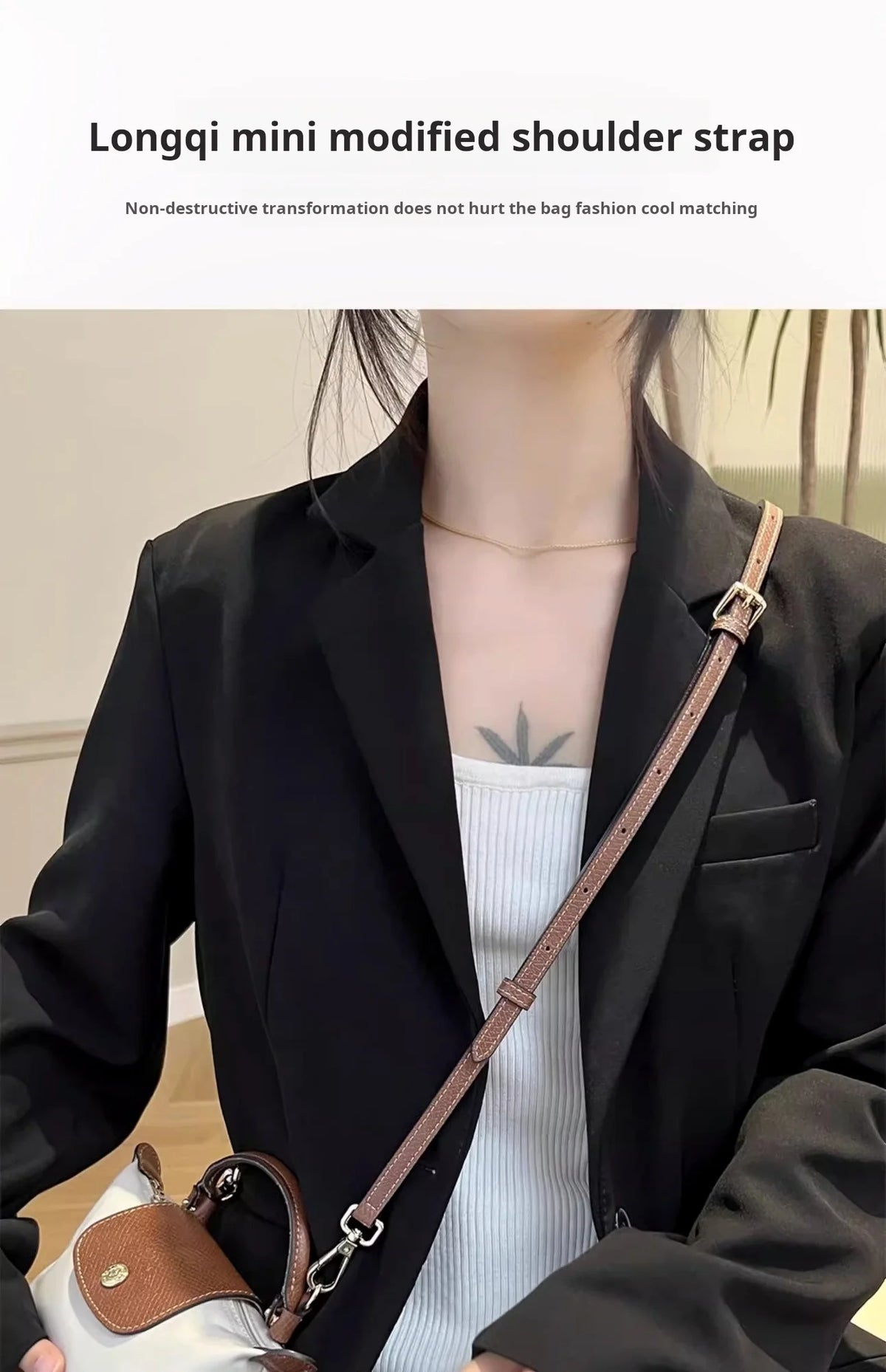 A woman wearing a black blazer is shown with a brown leather modified shoulder strap accessory.