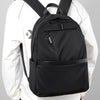 A black ultralight waterproof laptop backpack worn by a person in a white long-sleeved shirt.