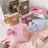 A collection of leopard print and pastel makeup bags and skincare organizers displayed on a white shelf.