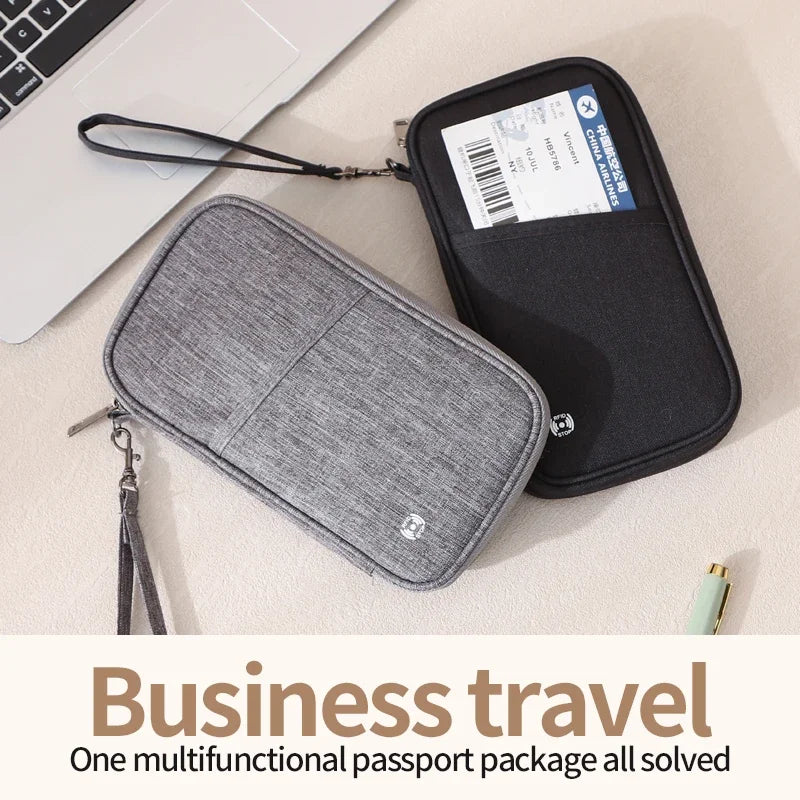 Cartera multifuncional de pasaporte negra y gris junto a una laptop, diseñada para viajes de negocios seguros.