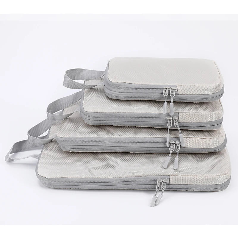 A stack of four light gray vertical travel organizer bags with fabric straps.