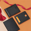 A set of black carbon fiber microfiber wallets and a red tie lying on an orange background.