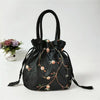Clutch de terciopelo negro con lazo, bordado floral dorado y un adorno de tela floral