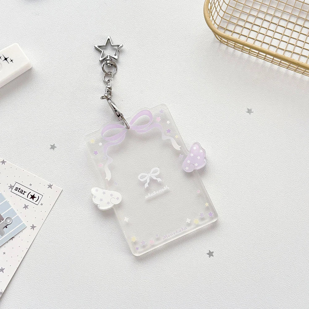 Clear acrylic photocard holder with a silver charm and purple ribbon decoration