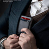 A man wearing a suit jacket is holding a slim minimalist card wallet with various cards inside.