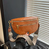 A brown PU leather crossbody bag with a gold-toned adjustable strap is displayed against a light background.
