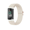 A beige stretchy nylon watch band for a Fitbit device, shown looped.
