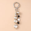 Silver pearl bow heart keychain with a circular ring and dangling pearls