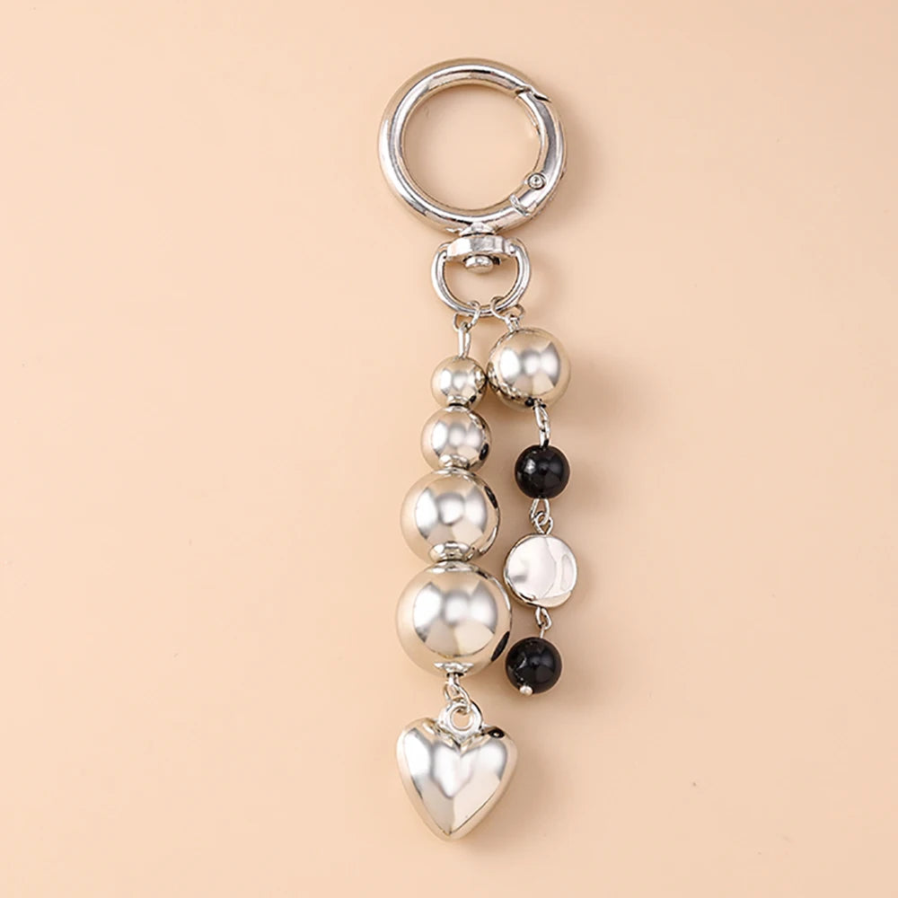 Silver pearl bow heart keychain with a circular ring and dangling pearls