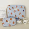 A light blue and white striped cosmetic makeup bag featuring small bear illustrations.