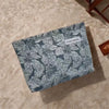 Bolsa de almacenamiento con cremallera en lienzo con estampado floral gris y blanco sobre una superficie beige.