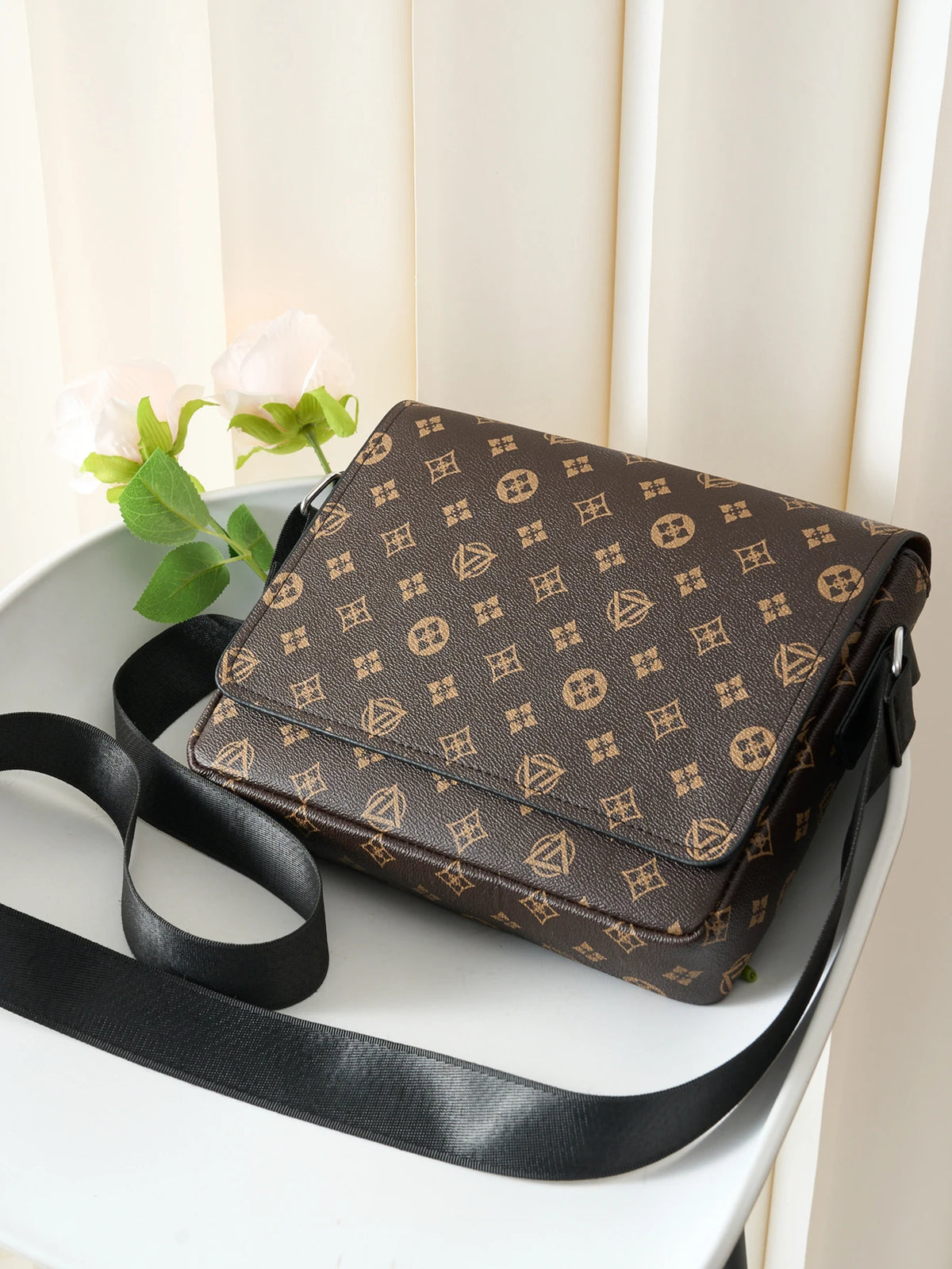 A brown leather men's casual crossbody bag with an easy flap design resting on a white surface.