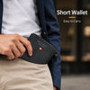 A hand is holding a black short wallet inside the pocket of light tan trousers, next to a dark blue jacket.