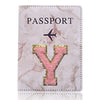 Carátula de pasaporte texturizada rosa y dorado con una gran letra Y grabada en la parte delantera.