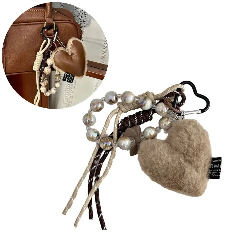 Brown leather heart pendant keychain featuring a long tassel and pearl beads.