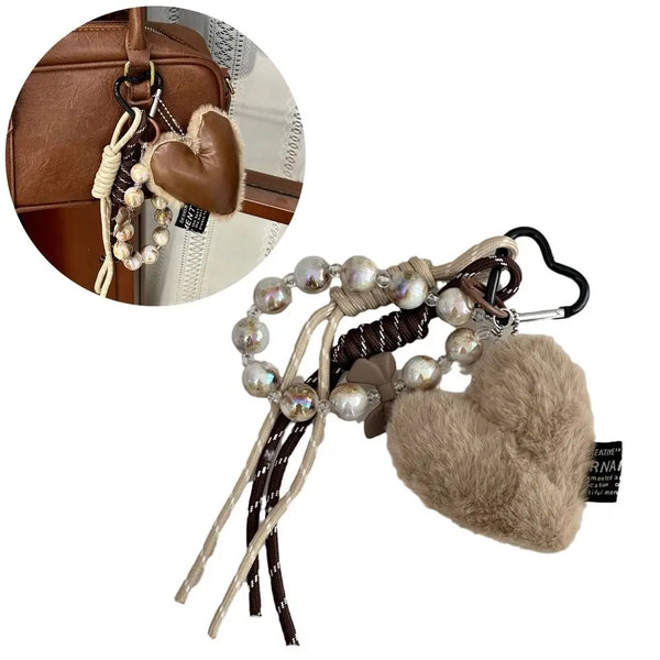 Brown leather heart pendant keychain featuring a long tassel and pearl beads.
