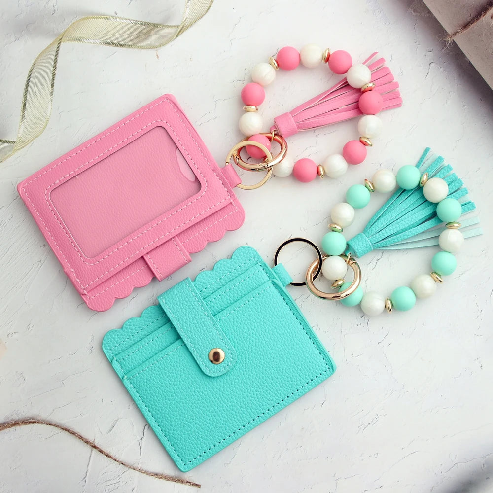 A pink and teal silicone bead and leather card wallet with decorative beaded straps.
