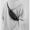 Gray water-resistant nylon jacket with a black waist bag worn on the back