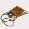 Bolso cruz de borla marrón boho con correa de cuero y accesorios.