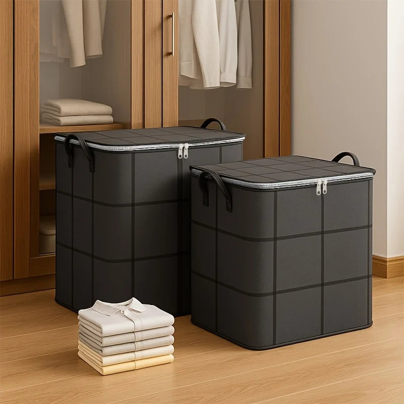 Deux sacs de rangement pliables et robustes gris foncé sur un plancher en bois.