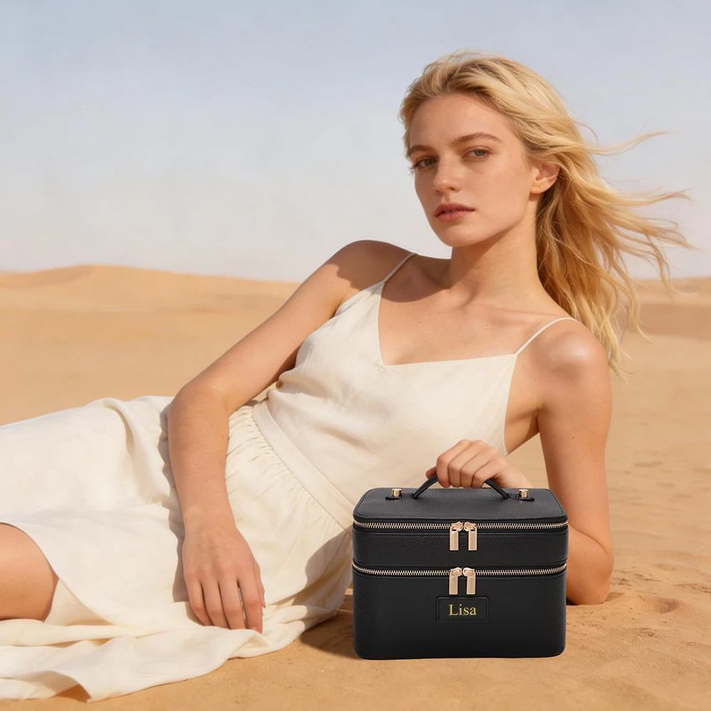 A blonde woman lies in a desert landscape holding a black double-layer makeup storage case.