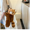 A brown red panda plush toy is displayed next to a white shirt, suggesting it is a soft furry crossbody bag.