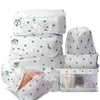 A set of white mesh packing cubes in various sizes with green leaf patterns for travel organization.