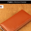 A brown genuine leather zipper wallet shown on a textured orange background.