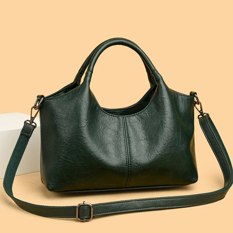 A dark green leather women's casual crossbody shoulder bag with a strap resting on a light background.