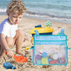 A young child is playing with a hanging bath toy organizer bag filled with colorful toys on a sandy beach.