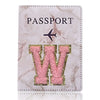 Cubierta de pasaporte texturizada rosa y dorado con una gran W grabada y un ícono de avión.