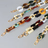 A collection of multi-color acrylic chain straps featuring various shades of brown, green, white, and black.