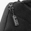 A close-up of a black resettable 3-digit combination padlock attached to a black fabric bag.