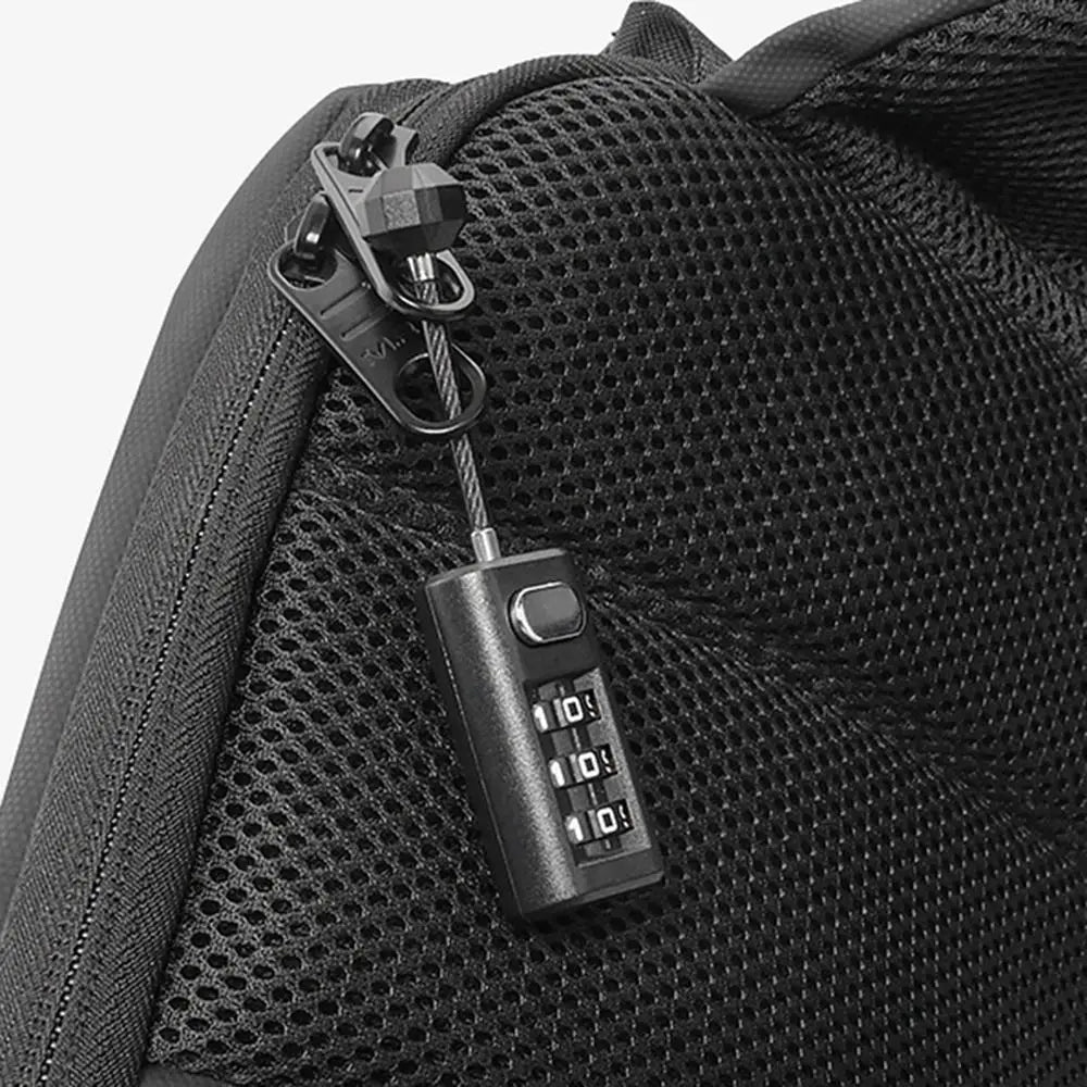 A close-up of a black resettable 3-digit combination padlock attached to a black fabric bag.